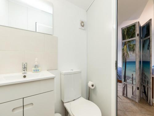 La salle de bains blanche est pourvue de toilettes et d'un lavabo. dans l'établissement Akivillas Manta Rota Shell II, à Manta Rota