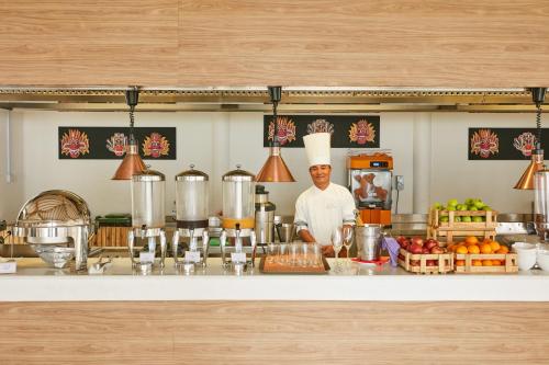 a man standing behind a counter in a kitchen at Sun Siyam Iru Veli - 24 Hours Premium All-Inclusive with Free Transfers in Dhaalu Atoll