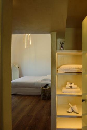 a bedroom with a bed and a shelf with shoes at LF Suites & Villas in Imerovigli