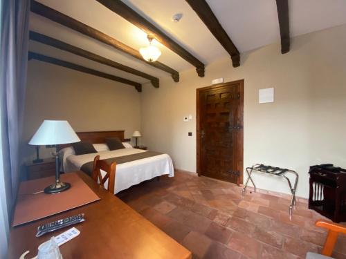 a hotel room with a bed and a desk with a desk at Hotel Rural El Lagar de Nemesio in Perales de Tajuña