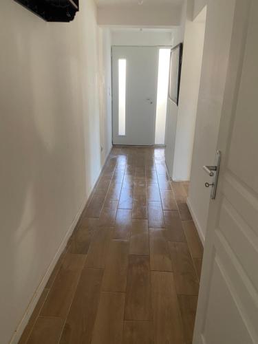a hallway with a wooden floor and a door at Studio proche bordeaux in Cadaujac