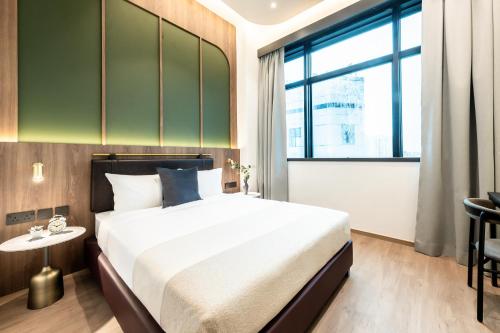 a bedroom with a large bed and a large window at Owen House by Habyt in Singapore