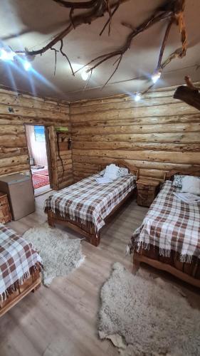 a bedroom with two beds in a log cabin at Кереге-Таш in Karakol