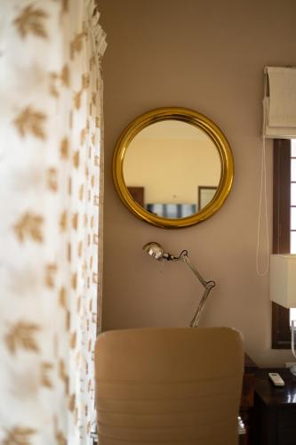 a mirror in a room with a chair and a lamp at Luho 187 in Bengaluru