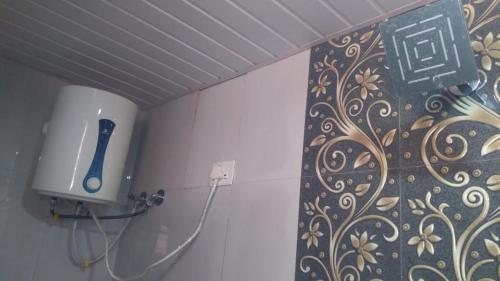 a bathroom with a hair dryer on a wall at Vinee's Kitchen and Motel in Koynanagar