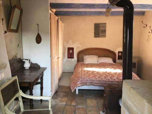 1 dormitorio con cama y mesa de madera en Les chambres d'Elise, en Collias