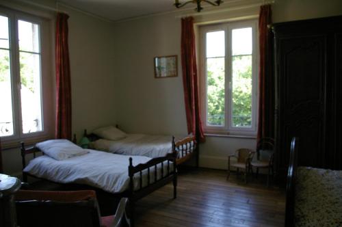 1 Schlafzimmer mit 2 Betten und 2 Fenstern in der Unterkunft La Folia - Ferme de Lucqy 
