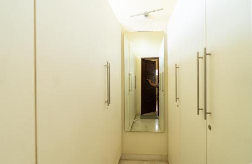 a hallway with white doors and a mirror at Luho 187 in Bengaluru