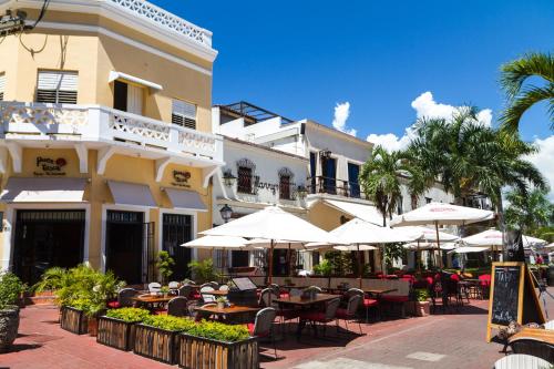 a restaurant with tables and umbrellas in front of a building at Spacious Quiet Double Room Near Megacentro - 10 min drive in La Viva