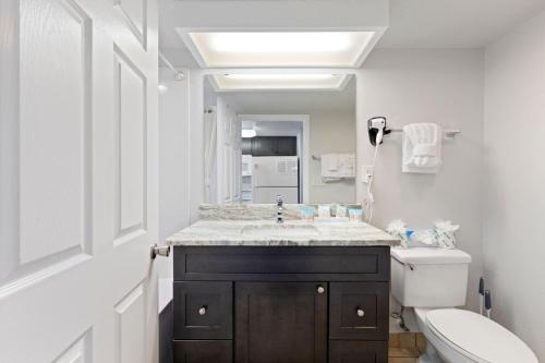 uma casa de banho com um lavatório, um WC e um espelho. em Atlantica 11th Floor Gem! em Myrtle Beach