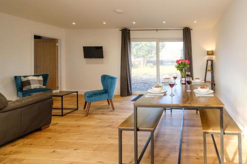 een woonkamer met een tafel en een bank bij Three Tuns - Garden Suite 1 in Wickham Market