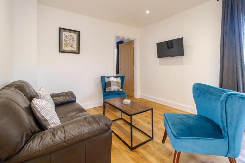 a living room with a couch and a chair at Three Tuns - Garden Suite 1 in Wickham Market