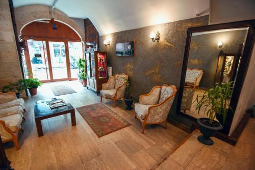 a living room with chairs and a table and a mirror at Taşhan Hotel in Edirne