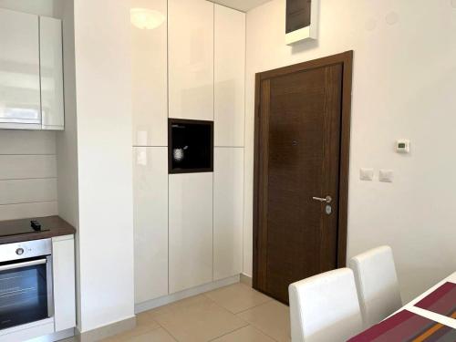 a kitchen with a wooden door and white walls at Lavender Bay Apartment in Donji Morinj