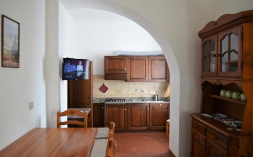 a kitchen with wooden cabinets and a table and a dining room at Agriturismo Le Case di San Vivaldo in Montaione