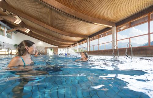 zwei Frauen im Wasser in einem Schwimmbad in der Unterkunft Garni Appartements Almrausch in Burgeis