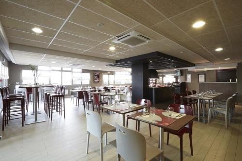 a dining room with tables and chairs in a restaurant at Campanile Blanc-Mesnil in Le Blanc-Mesnil