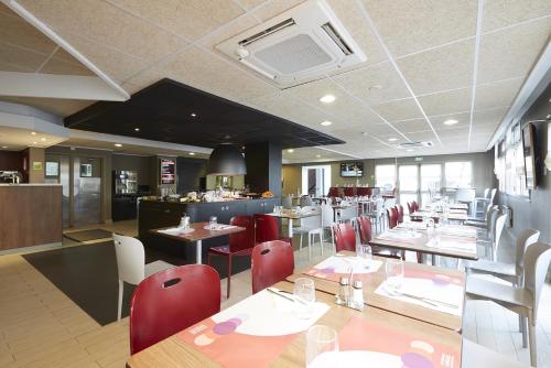 a dining room with tables and chairs and a restaurant at Campanile Blanc-Mesnil in Le Blanc-Mesnil