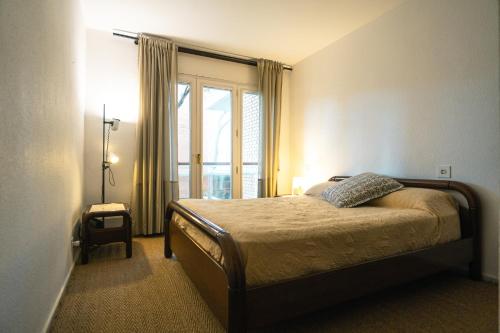 1 dormitorio con cama y ventana grande en Gavà Beach Apartment, en Gavà