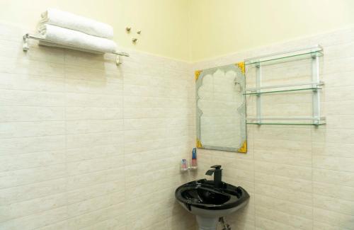 a bathroom with a sink and a mirror and towels at Kiteme Comfort Lodge in Arusha