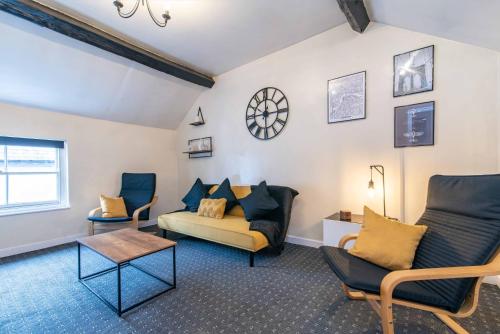 a living room with a couch and two chairs at Characterful 2 bedroom apartment - Central location in Castle Donington