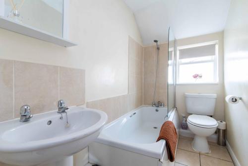 a white bathroom with a sink and a toilet at Characterful 2 bedroom apartment - Central location in Castle Donington