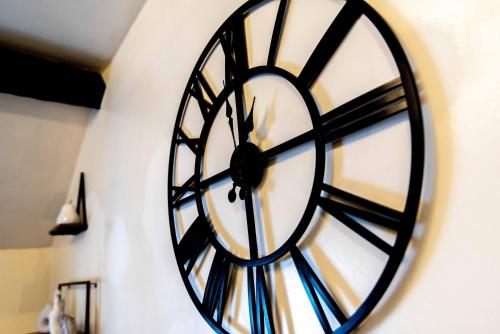 a black and white clock on a wall at Characterful 2 bedroom apartment - Central location in Castle Donington