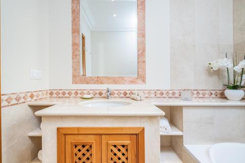 uma casa de banho com um lavatório e um espelho em Villa Sea Renity - Palheiro Village by ALMA Holiday Rentals em Funchal