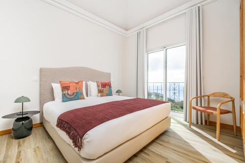 1 dormitorio con cama grande y ventana grande en Villa Sea Renity - Palheiro Village by ALMA Holiday Rentals en Funchal