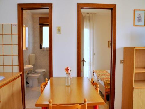 une cuisine avec une table et un vase de fleurs. dans l'établissement Luminous flat 400 m from the beach for 4 guests, à Bibione
