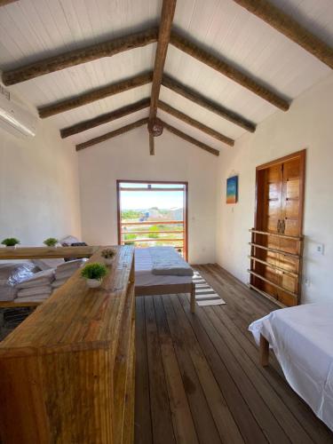 Habitación con 2 camas y mesa de madera. en Chalé Maria Bonita Caraiva, en Caraíva