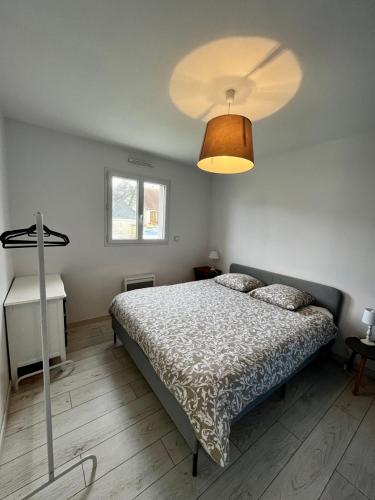 - une chambre avec un lit et un grand éclairage dans l'établissement Maison 3 ch vue sur mer confortable lumineuse belle terrasse grand jardin 10 mn à pied de la plage - proche supérette et Omaha Beach, à Vierville-sur-Mer