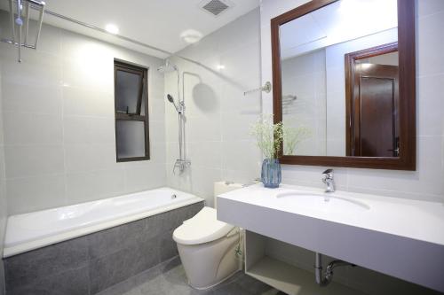 een badkamer met een wastafel, een toilet en een spiegel bij Sumitomo9 Apartments & Hotel - alley 58 Dao Tan in Hanoi