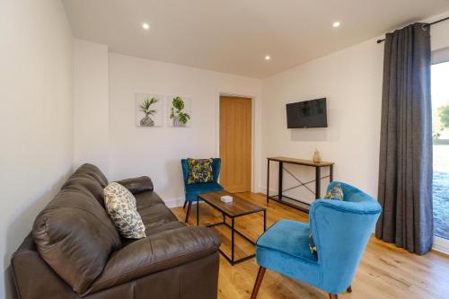 a living room with a couch and two chairs at Three Tuns - Garden Suite 2 in Wickham Market