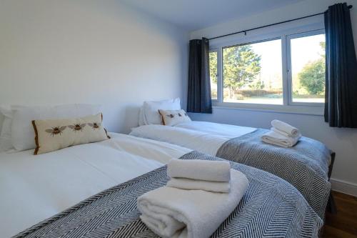 dwa łóżka w pokoju z oknem w obiekcie Three Tuns - Garden Suite 2 w mieście Wickham Market