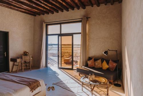 - une chambre avec un lit et une grande fenêtre dans l'établissement Caravan by Habitas Dakhla, à Dakhla