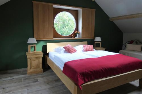 a bedroom with a bed with a red blanket and a window at Un air de bourlingueurs in Pepinster