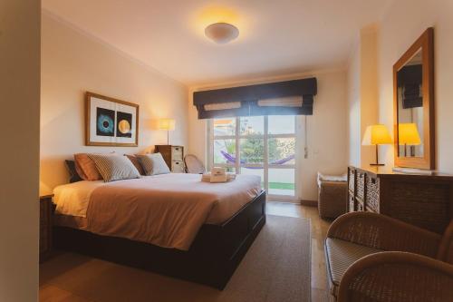 a bedroom with a large bed and a window at Best Houses 40 - You me and the sea in Ferrel
