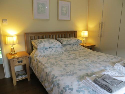 1 dormitorio con 1 cama con 2 mesitas de noche y 2 lámparas en Easter Cottage, en Dersingham