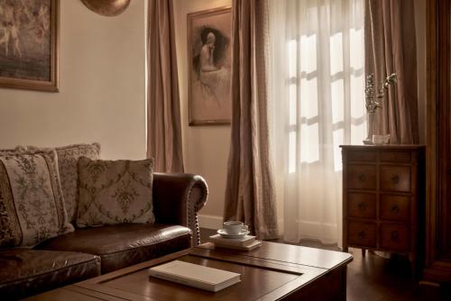 a living room with a couch and a table and a window at Hotel Ippoliti in Nafplio