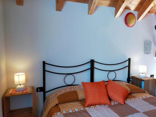 ein Schlafzimmer mit einem großen Bett mit orangefarbenen Kissen in der Unterkunft B&B CA' DEL PITUR CICOGNA in Cossogno