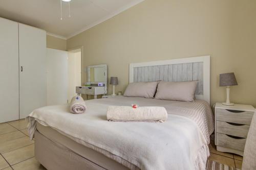 a bedroom with a large bed with two towels on it at Ovendales Self Catering Cottage in Benoni