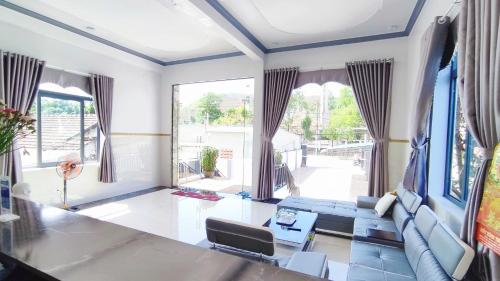 sala de estar con sofá azul y ventana grande en Hotel Mỹ Vy en Tánh Linh