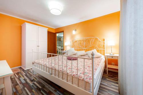 a bedroom with a bed with orange walls at Apartments Vera in Dubrovnik