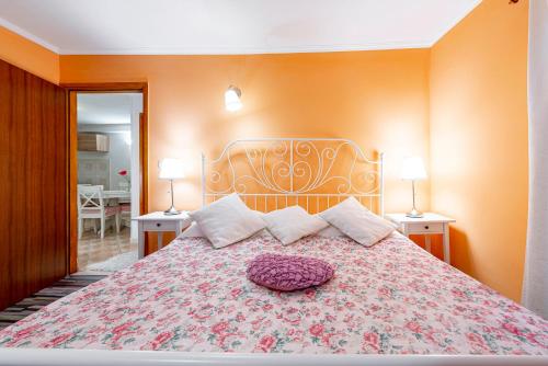 a bedroom with a large bed with a purple pillow on it at Apartments Vera in Dubrovnik