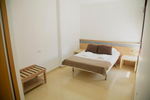 イスラ・プラナにあるBe Free Isla Planaのベッドとベンチ付きの小さな部屋です。