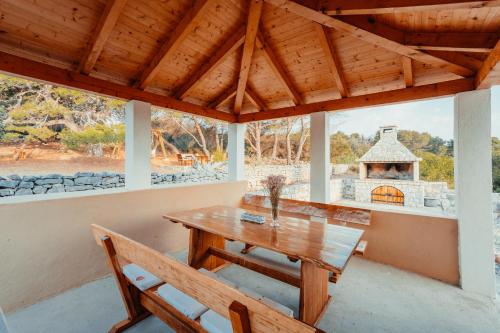 a dining room with a wooden table and chairs at Guest House Sakarun in Veli Rat