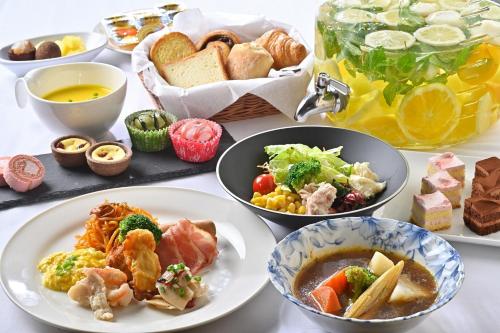 a table topped with plates of food and bowls of food at Hotel Keihan Sapporo in Sapporo