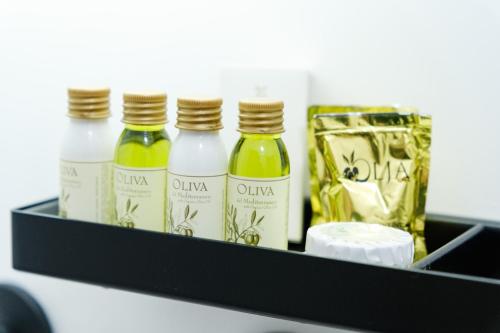 a shelf with three bottles of wine and a bag at Ostuni Luxury Room in Ostuni