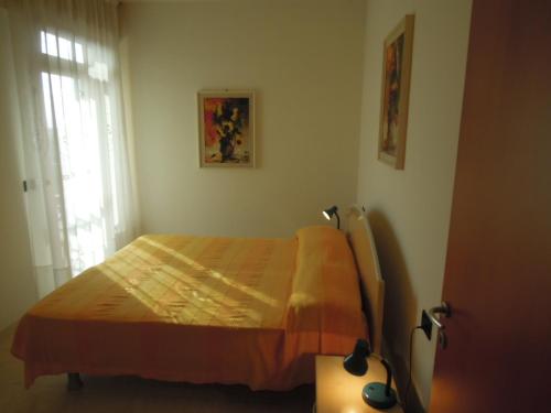 a bedroom with a bed and a window at Homely 1 bedroom flat with side sea view in Bibione